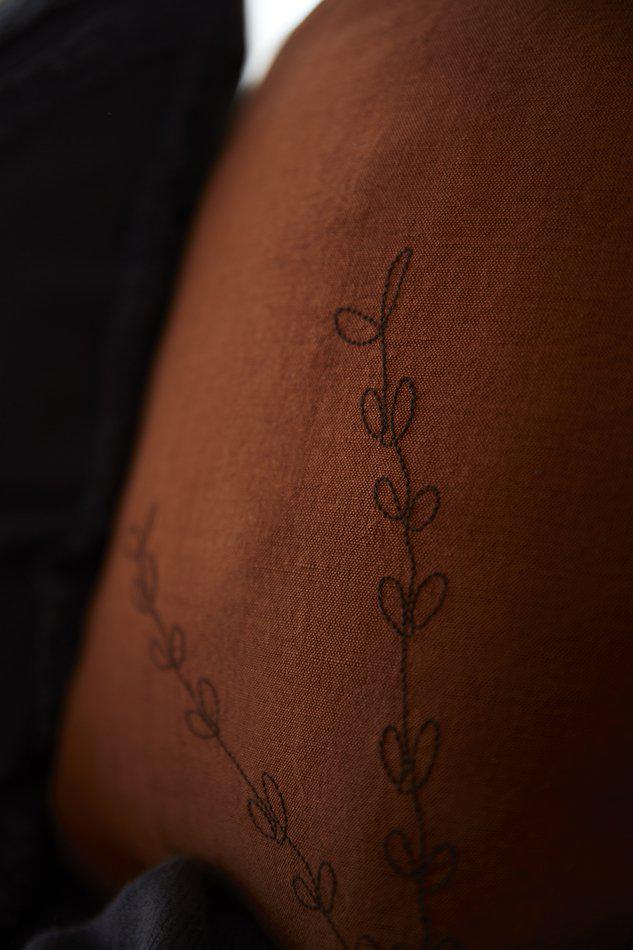 Närbild på Amie kuddfodral i linneblandning med broderad detalj