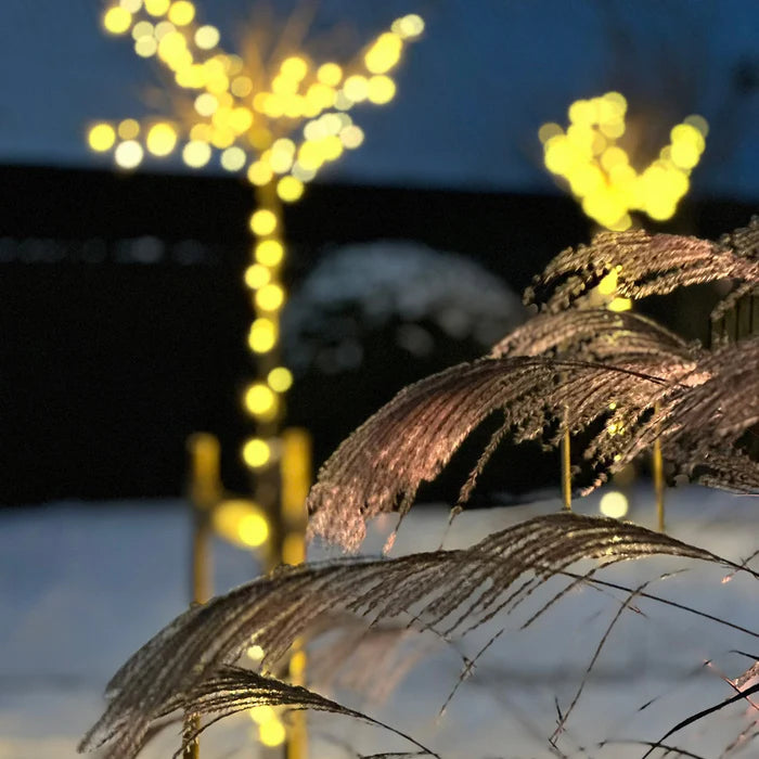 Twinky Pro monterad längs ett staket för dekorativ trädgårdsbelysning under vintern.