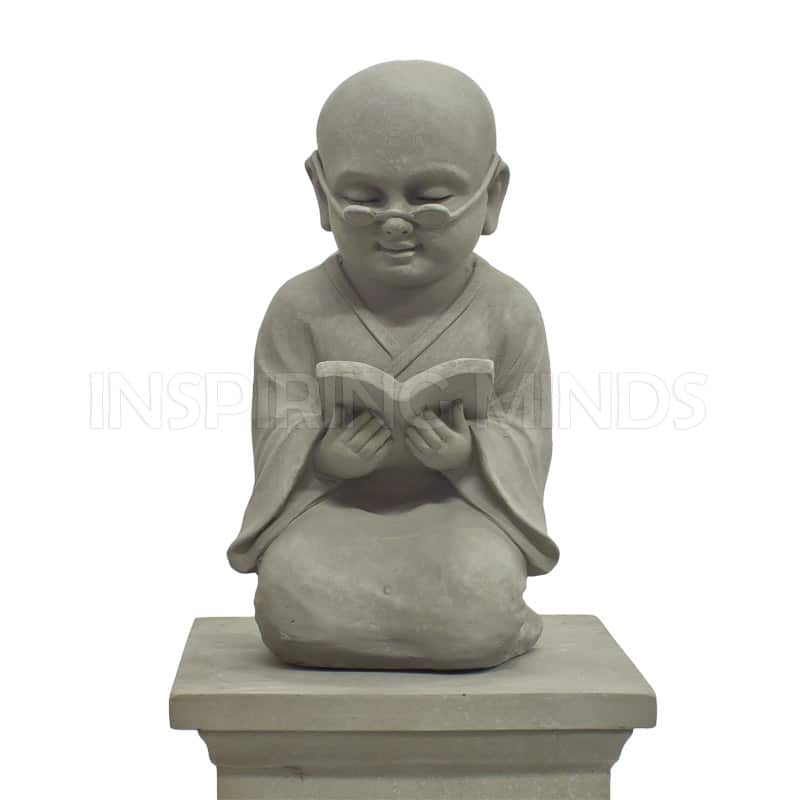 Grå trädgårdsstaty i form av en Shaolinmunk som läser en bok