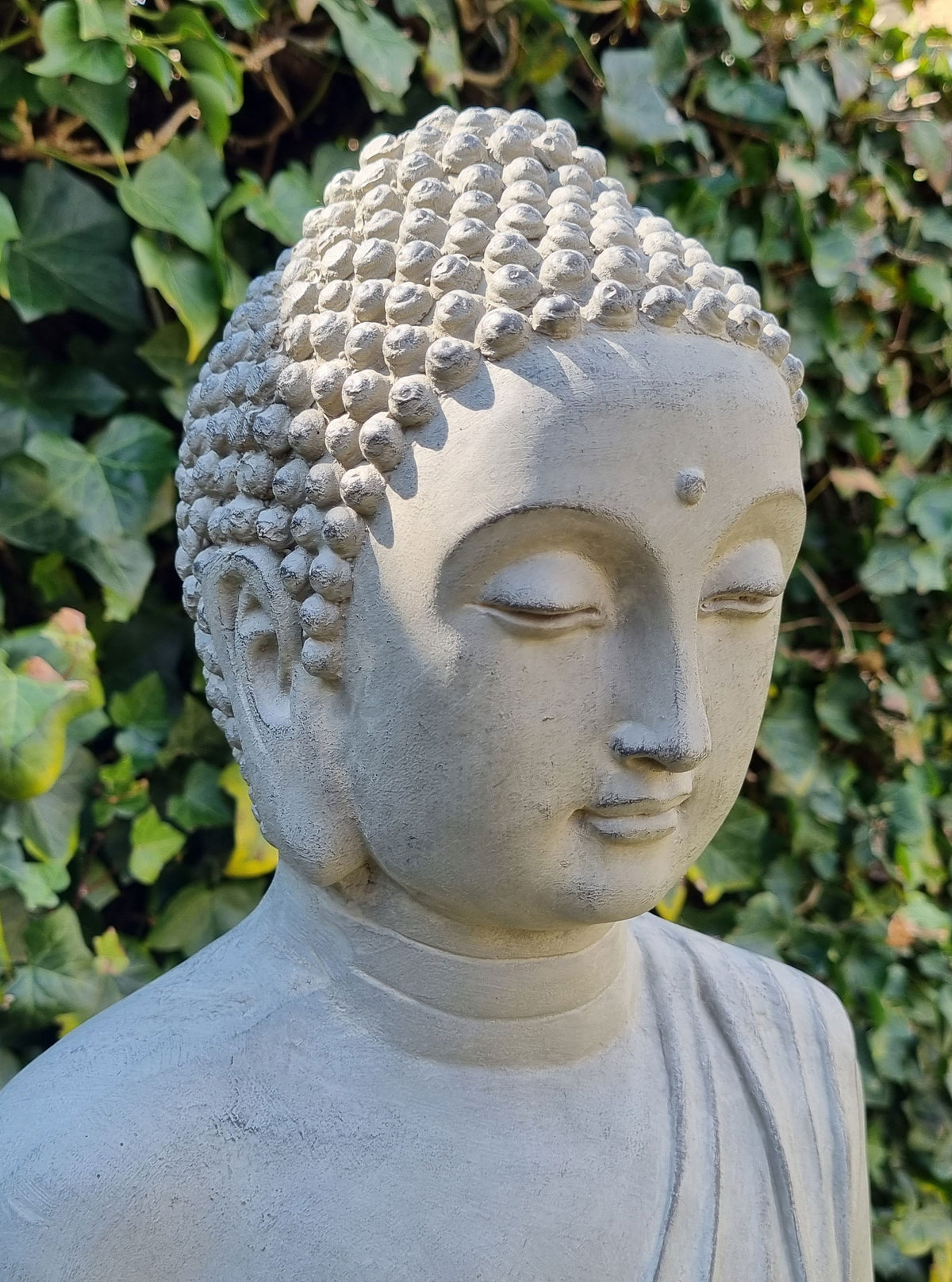 Detaljbild på skålen som hålls av den stående Buddha-statyn