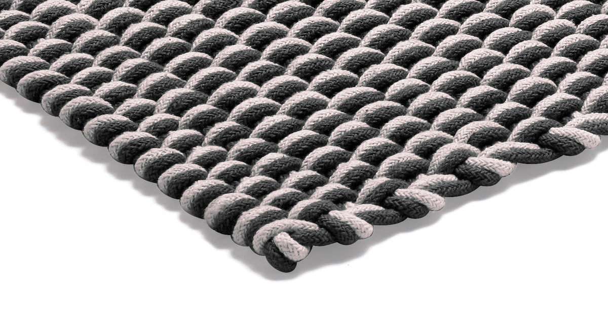 Närbild på strukturen av den flätade repmattan Rope i grafit och natur