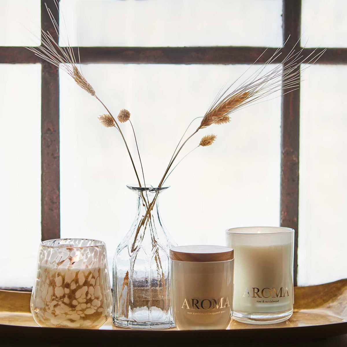 Närbild på AROMA doftljus med trälock och brun presentask i bakgrunden