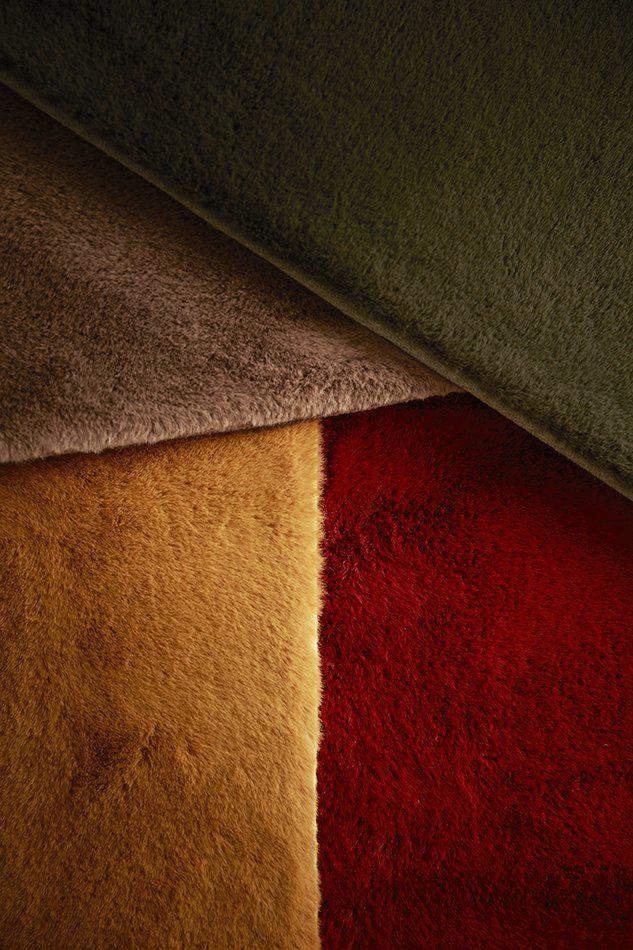 Närbild på materialet av den tuftade mattan Ninha i rostbrun nyans