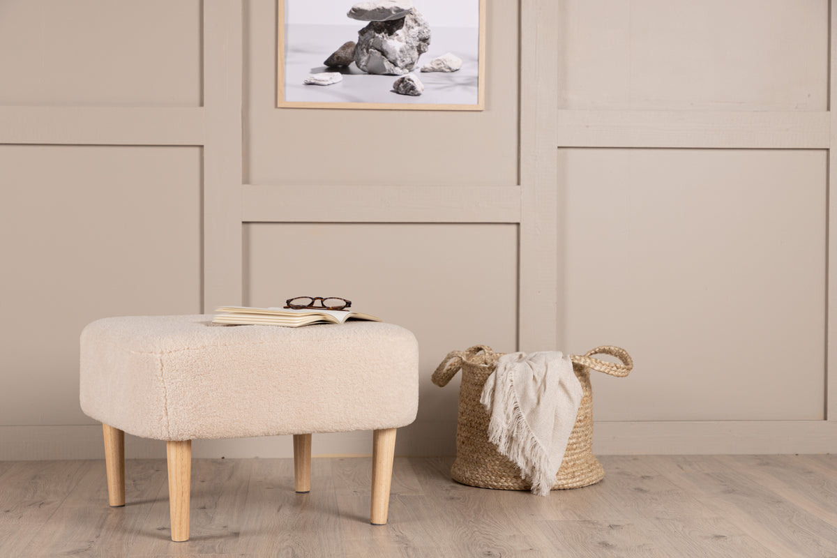 Närbild på sittpuffen Salina framifrån som visar den mjuka texturen och eleganta designen.