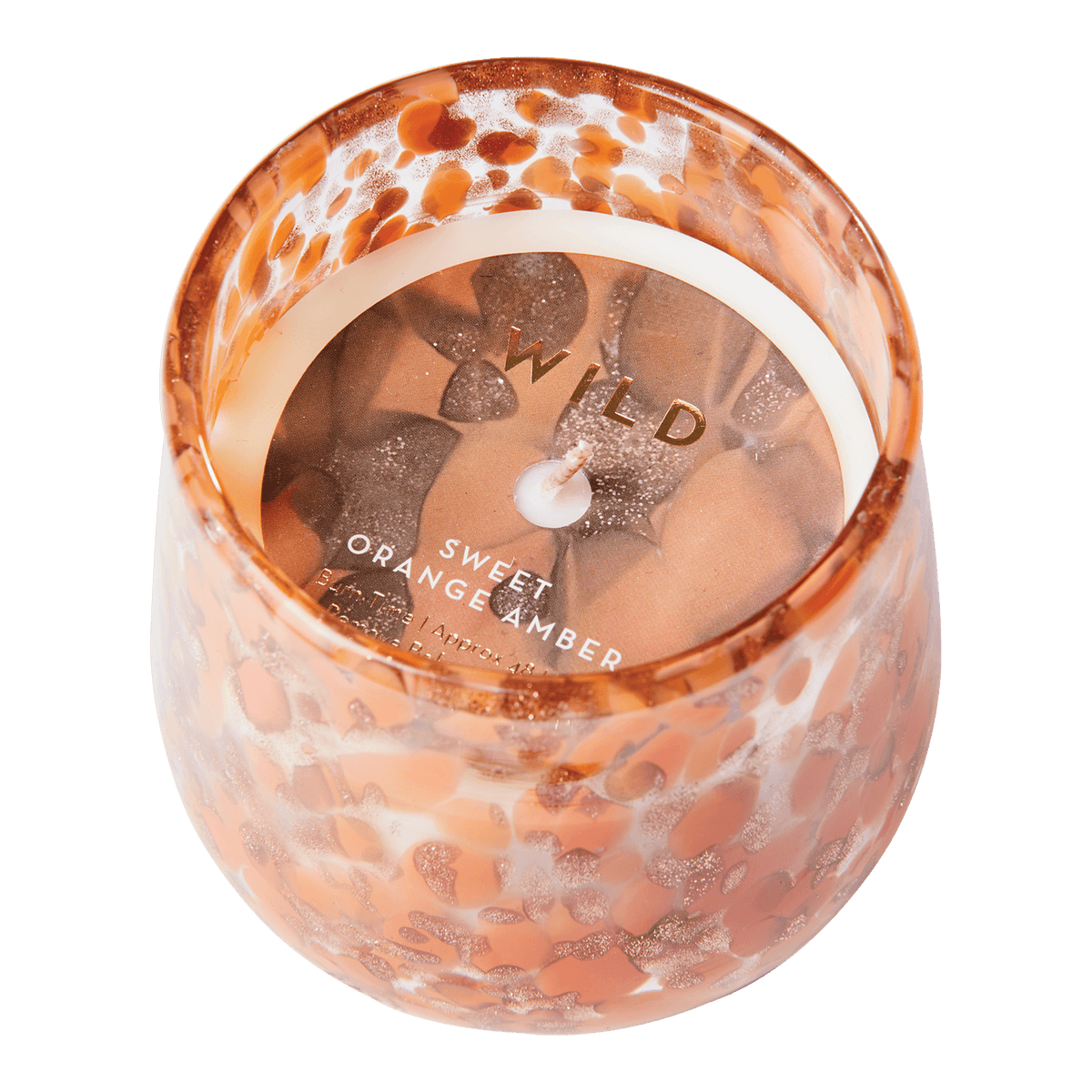 Närbild på sojavaxljus med doft av orange och amber i mönstrat glas
