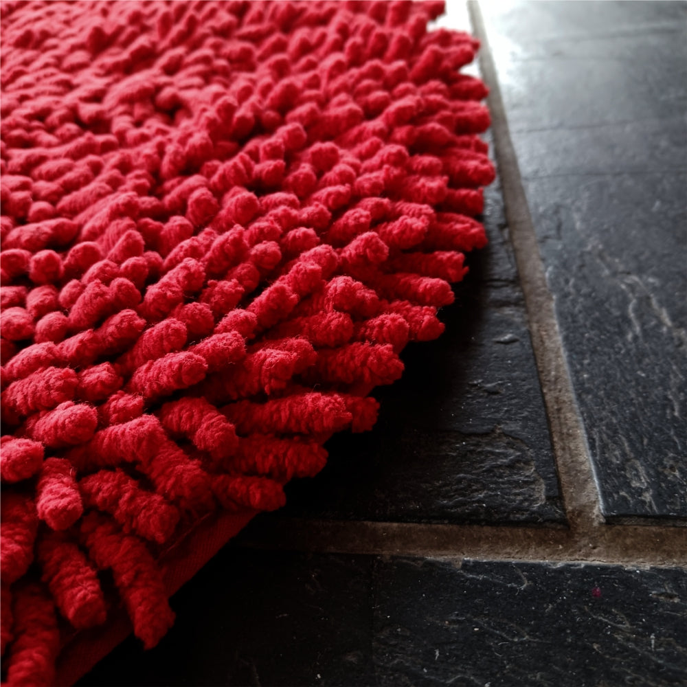 Rasta rund röd matta sedd ovanifrån på vit bakgrund