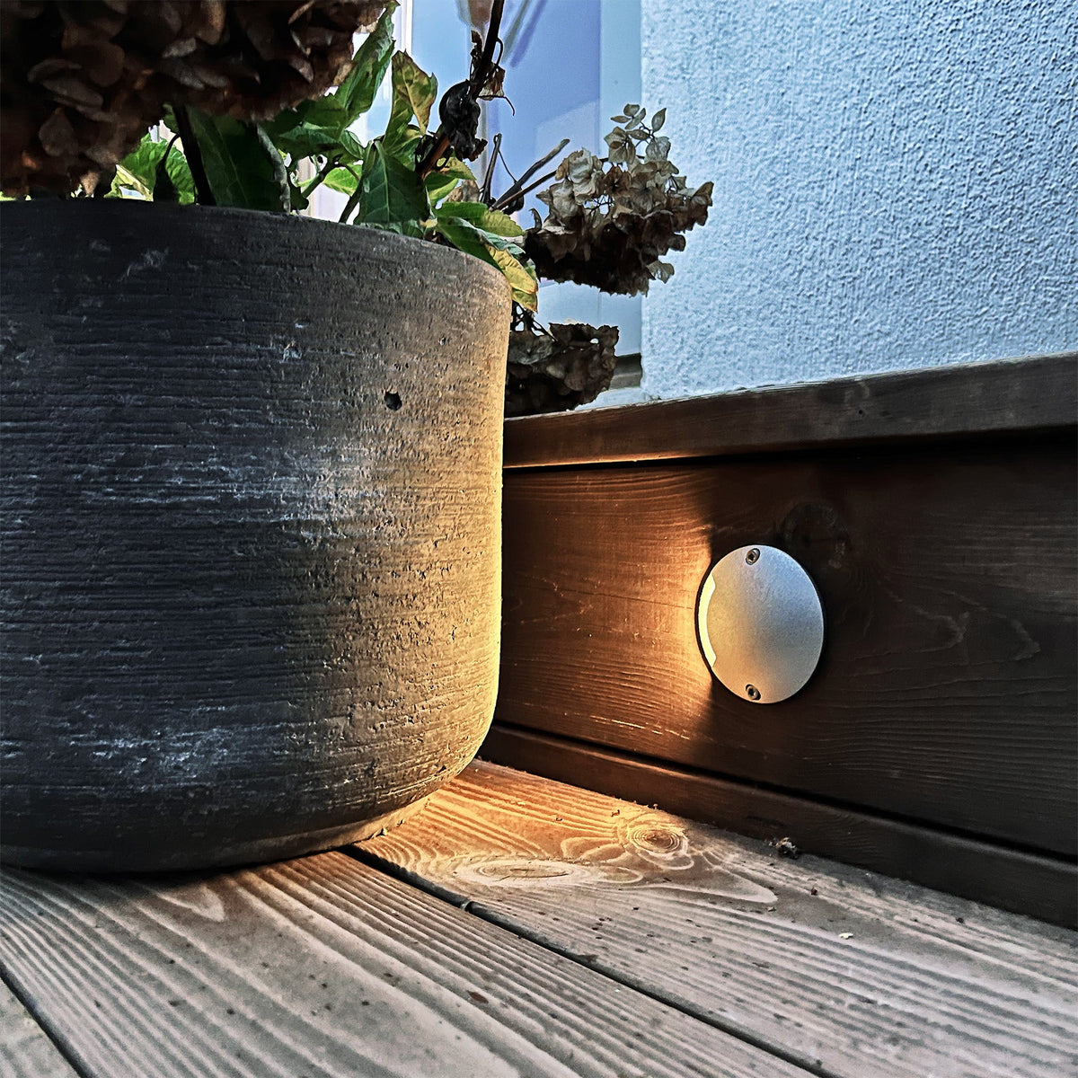 Installation av Zenit silver lampa på en träfasad med varmvitt nedåtriktat ljus