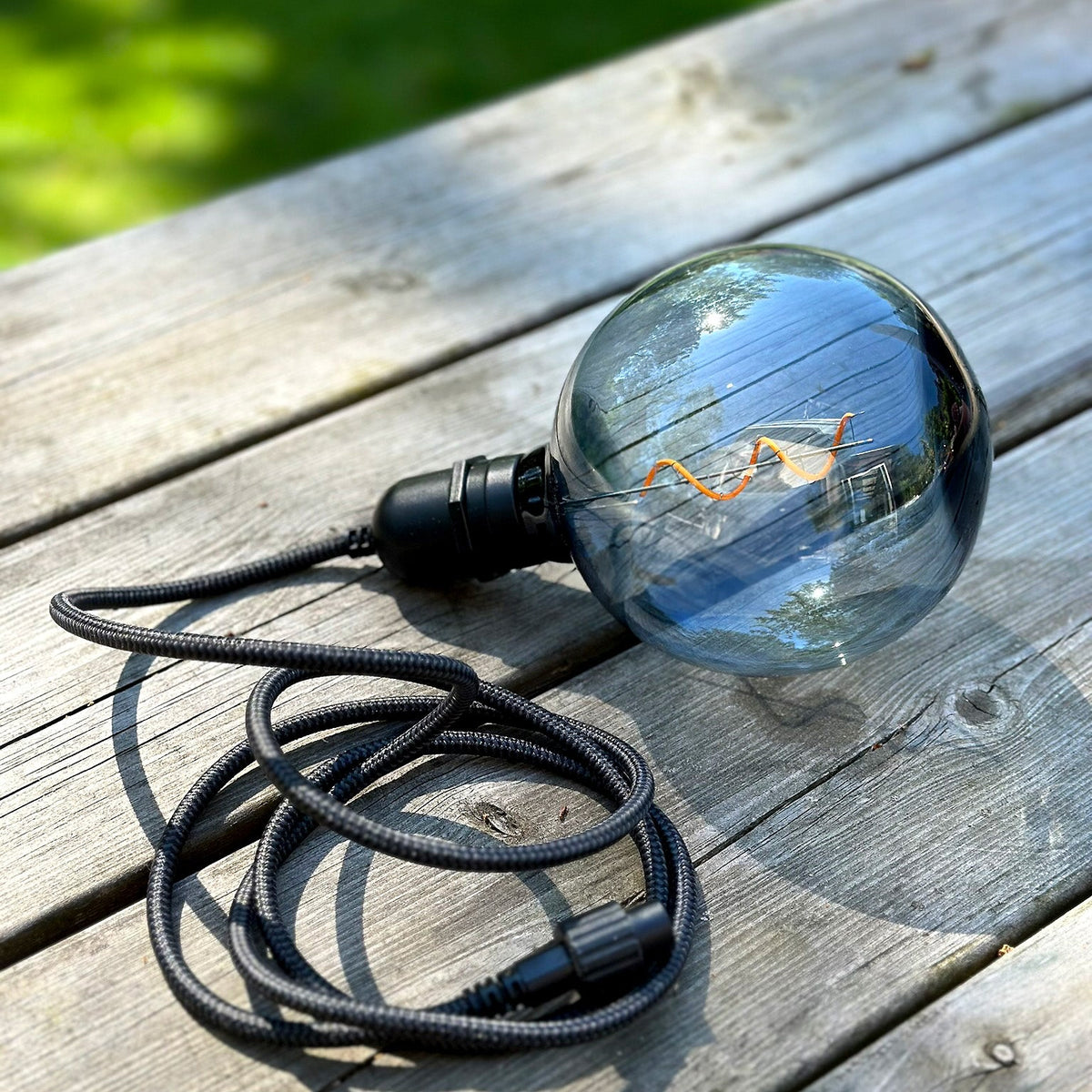 DecoXL Smoke rökfärgad glödlampa mot en vit bakgrund för utomhusbruk