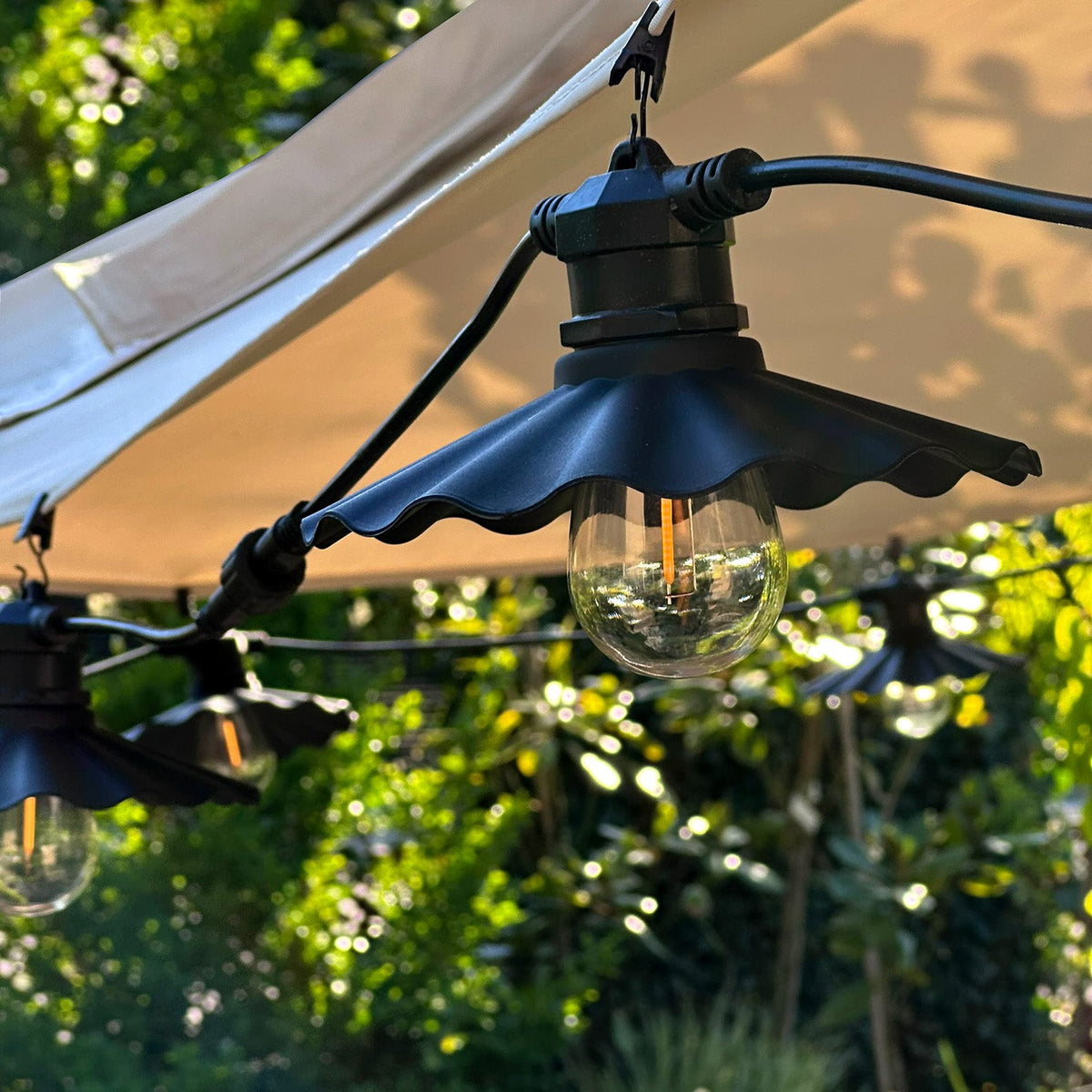 Miljöbild på Shady lampskärmar som hänger i ett träd