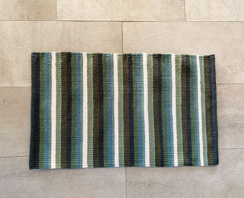 Närbild på den vävda strukturen i bomullsmattan Stripe Salvia