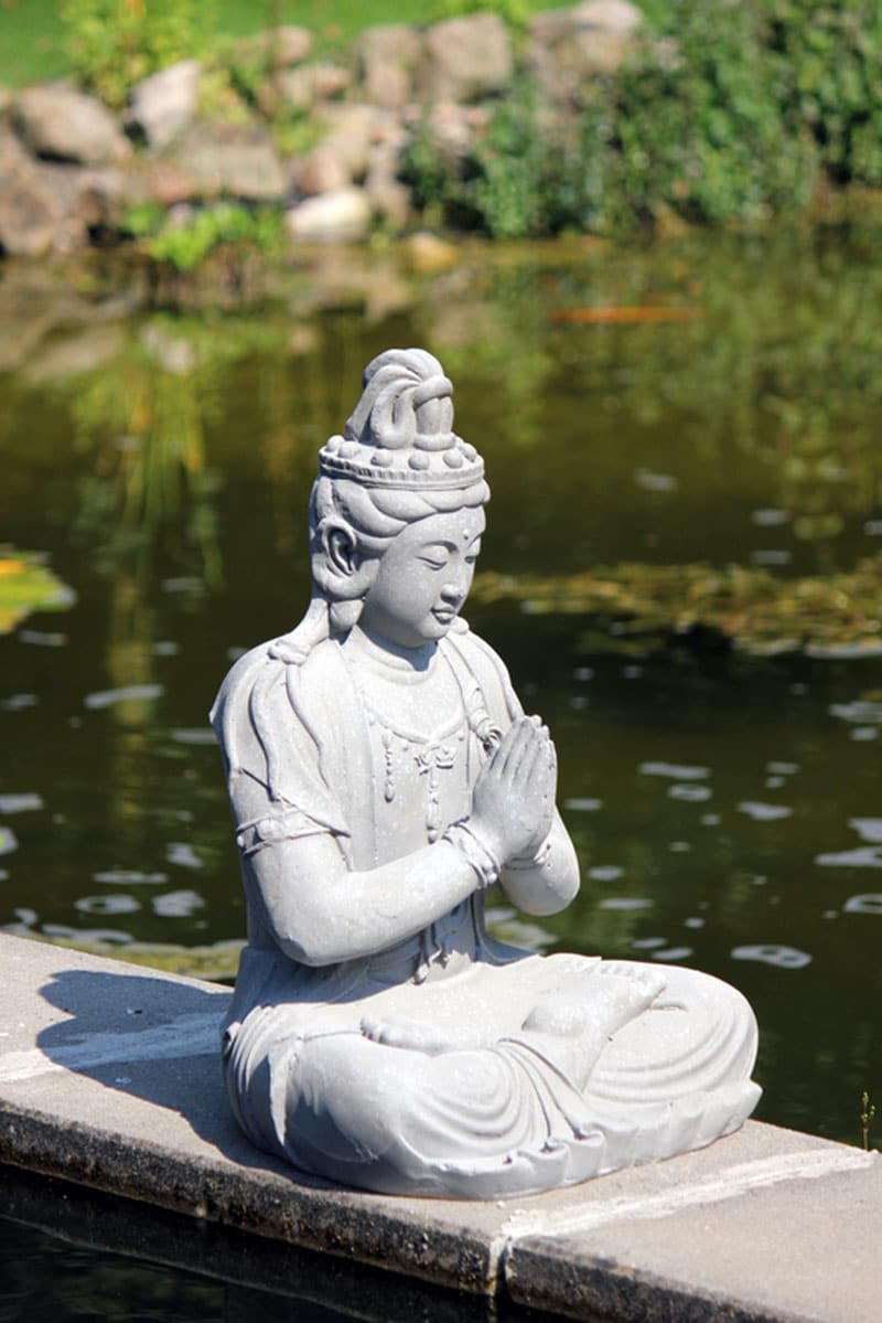 Sittande Guanyin staty för trädgård och meditation i profil