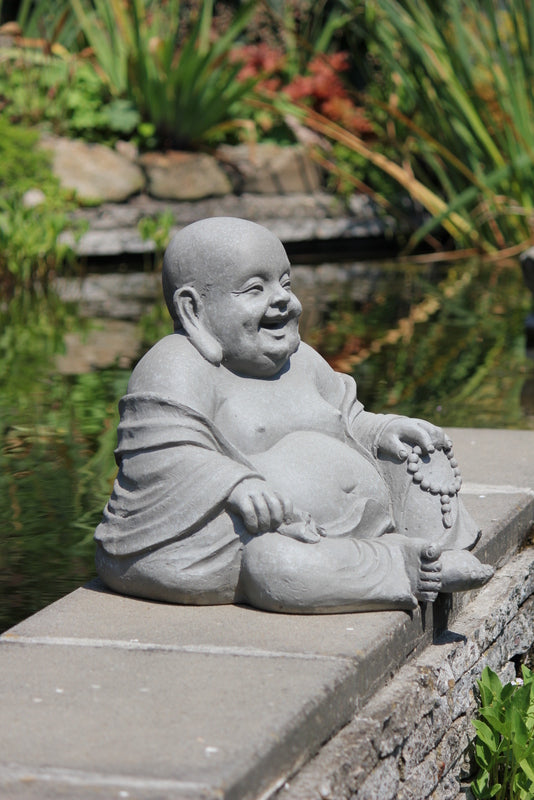 Närbild på en leende Glad Buddha staty med detaljerade drag och radband