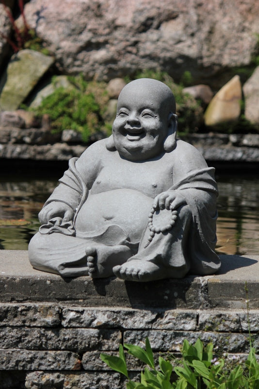 Närbild på glad sittande Buddha staty lämplig för utomhusbruk