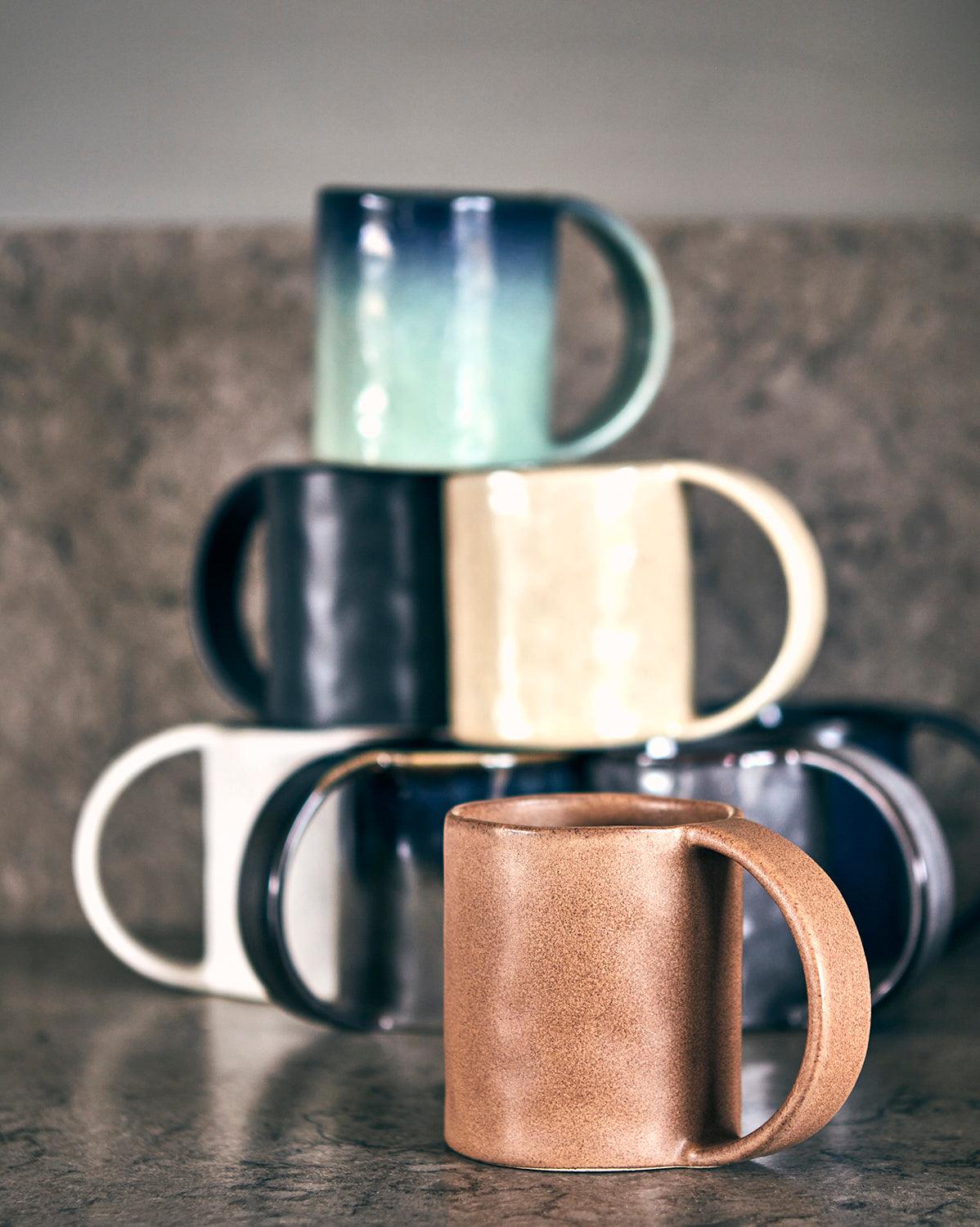 Uppsättning av fyra mörkblå SVEA muggar i stengods för kaffe och te