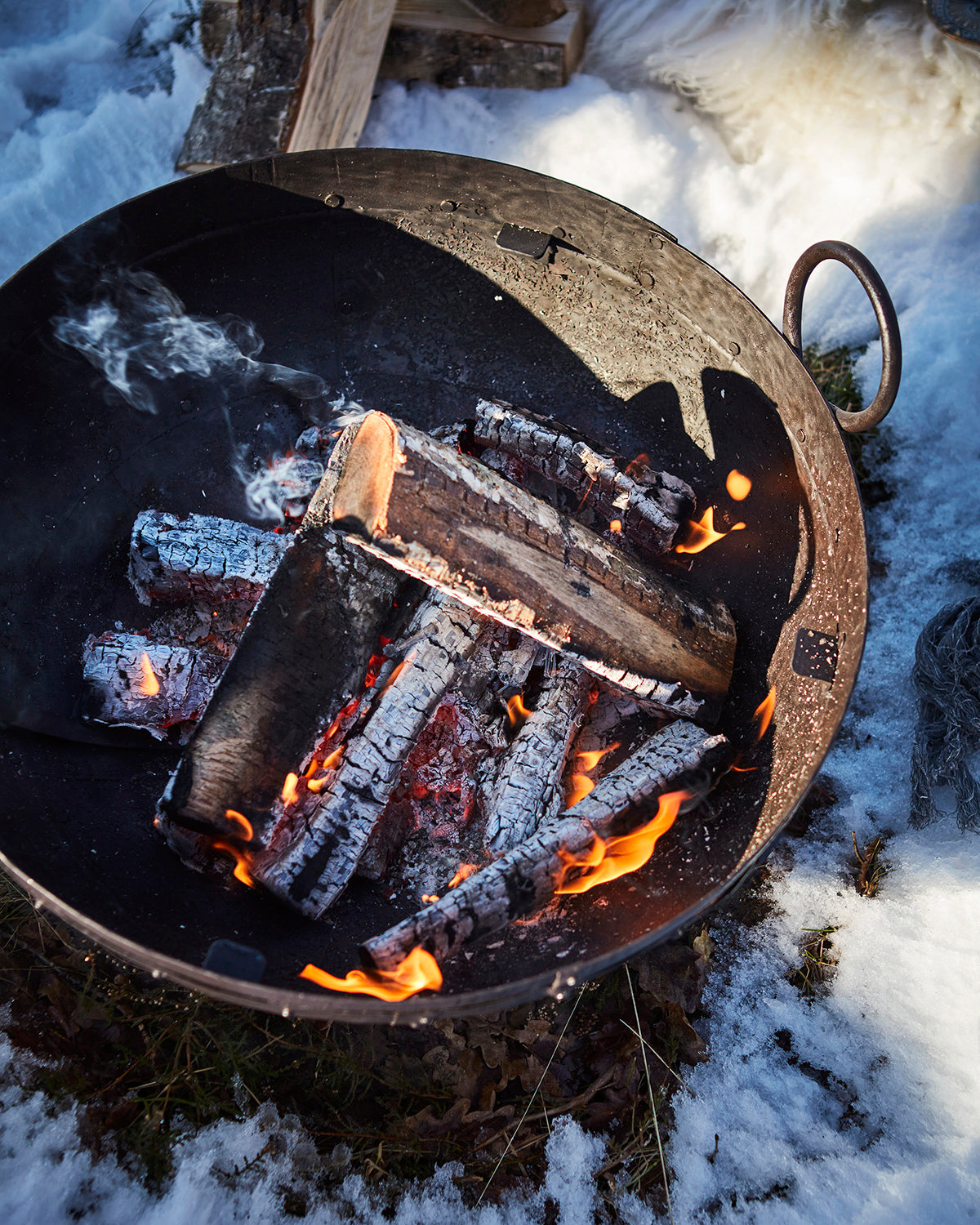 Närbild på den rostiga finishen och handtaget på BARBEQUE eldkorg